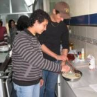 Dos inmigrantes participan en un curso de cocina de la Asociación Sin Fronteras, en Astorga