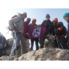 Coronando la cima de España con la bandera de la expedición leonesa.