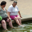 Dos personas se refrescan en una fuente en Inglaterra. KIYOSHI OTA
