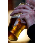 Un hombre bebe una pinta de cerveza en un bar.