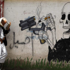 Un hombre camina junto a un grafiti antitabaco en Saná (Yemen).  YAHYA ARHAB