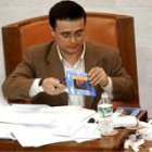 El procurador socialista José María Crespo rellena felicitaciones de Navidad durante el Pleno