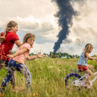 Una imagen de una niña en bicicleta junto a dos amigas en un prado en el noroeste de Ucrania, en "un momento de despreocupación bajo las oscuras nubes de la guerra", es la ganadora del concurso internacional en el que el Fondo de las Naciones Unidas para la Infancia (UNICEF) en Alemania elige la mejor foto del año. PATRYK JARACZ
