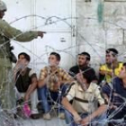 Un soldado israelí vigila a varios palestinos, detenidos ayer en la ciudad cisjordana de Hebrón