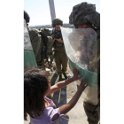 Una niña palestina trata de empujar a un soldado israelí.
