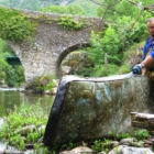 Uno de los operarios retira un colchón arrojado al río.