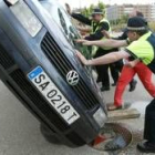 Varios policías intentan dar la vuelta a uno de los vehículos siniestrados