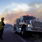 Un bombero vigila una carretera junto al incendio forestal a 115 km de Los Ángeles. PAUL BUCK
