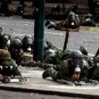 Guardias nacionales venezolanos se cubren de los disparos de los opositores en Caracas