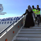 Los agentes trasladan a la joven detenida en el avión.