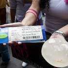 Una mujer sostiene unos implantes defectuosos de PIP.