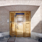 Puerta de acceso a San Isidoro, en la calle Sacramento de León; abajo, detalle de la vidriera del frontal de la puerta.