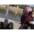 Una mujer con su hijo en brazos intenta cruzar la frontera entre Siria e Irak, en la localidad de Semalka, el día 21.