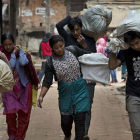 Ciudadanos de Bhaktapur, en Nepal, acarreando sus enseres.