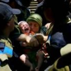Una mujer y su bebé son desalojados por soldados israelíes del asentamiento de Homesh