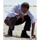 Obama coge una bola de brea en la playa de Port Fourchon.