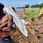 Un trabajador de la madera en la tarea de bajar troncos río Congo abajo hacia Kinshasa. MANUEL FÉLIX