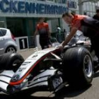 Un mecánico de la escudería McLaren empuja un coche de carreras en el circuito de Hockenheim