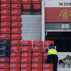 Miembros de seguridad rastrean las gradas de Old Trafford.