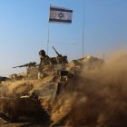 Un tanque del Ejército israelí en su camino hacia la franja de Gaza rodeado de polvo.