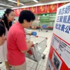Un grupo de clientas lee un aviso sobre las marcas de leche contaminadas en un supermercado de China