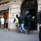 Uno de los tres detenidos por la Guardia Civil sale custodiado por agentes en Barcelona.