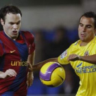 Andrés Iniesta pelea un balón con el defensa Ángel Domingo López.