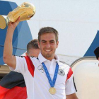 Lahm muestra la Copa del Mundo desde la escalerilla del avión a la llegada de la selección alemana a Berlín.