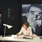 La reina firma en el libro de honor del museo escoltada por López y la ministra Sinde.