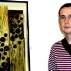 El pintor Karlos Viuda, junto a una de sus obras expuestas