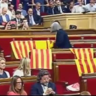 La diputada de Catalunya Sí que es Pot Àngels Martínez retira las banderas de España que habían dejado en su escaño los diputados del PP.