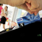 Una mujer usa su tarjeta de crédito.