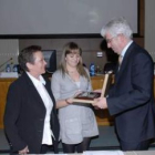 El rector de la Universidad le entrega una placa a la mujer y la hija de Rafael Rodríguez