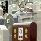 Un hombre pasea por un cementerio pekinés con una mascarilla puesta