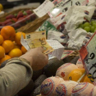 Una mujer paga por la compra de unos alimentos en un mercado.
