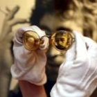 Las míticas gafas de John Lennon, con una imagen del líder del grupo al fondo