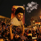 Un seguidor de Moqtada al Sadr sostiene una foto del clérigo en una concentración en la plaza Tahrir de Bagdad para celebrar el resultado electoral.