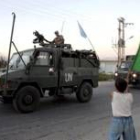 Un niño libanes ondea una bandera italiana al paso de un convoy