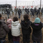 Un grupo de niños observa a los policías tras la alambrada. MAXIM GUCHEK