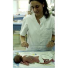 Una enfermera observa a uno de los cuatrillizos en su incubadora