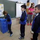 Varios alumnos de sexto de Primaria del colegio Marista San José reciclan el papel en el contenedor azul que se ha instalado en las aulas.
