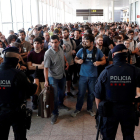 Agentes de los Mossos d'Esquadra y de la Policía Nacional controlan el acceso de personas a la terminal 1 del Aeropuerto de El Prat. ALEJANDRO GARCÍA.