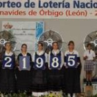 Unas jóvenes con trajes regionales muestran el número premiado en el sorteo de Benavides