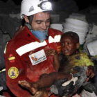 Óscar Vega con el niño al que rescató el viernes en Puerto Príncipe.