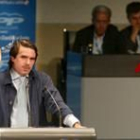 Un momento del discurso de Aznar ayer en León, al fondo los ex ministros Aparicio y Posada