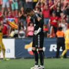 El portero del Nàstic, Manolo Reina, muestra su aflicción mientras los jugadores de Osasuna celebran uno de sus goles.