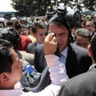 El presidente Correa es protegido del gas lacrimógeno durante la protesta de los efectivos policiale