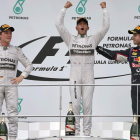 Hamilton, exultante, escoltado en el podio por Rosberg y Vettel.