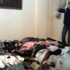 Un hombre muestra los cadáveres de algunos de los asesinados por el régimen.