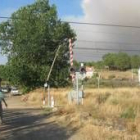 Vecinos de Porqueros observan en las cercanías de la vía del tren el fuego del domingo